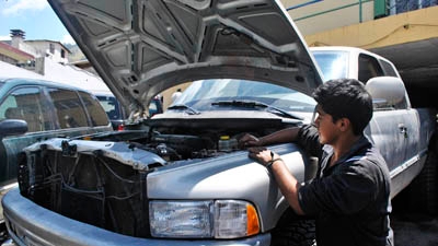 Photograph of Freddy Quelal working his auto shop.